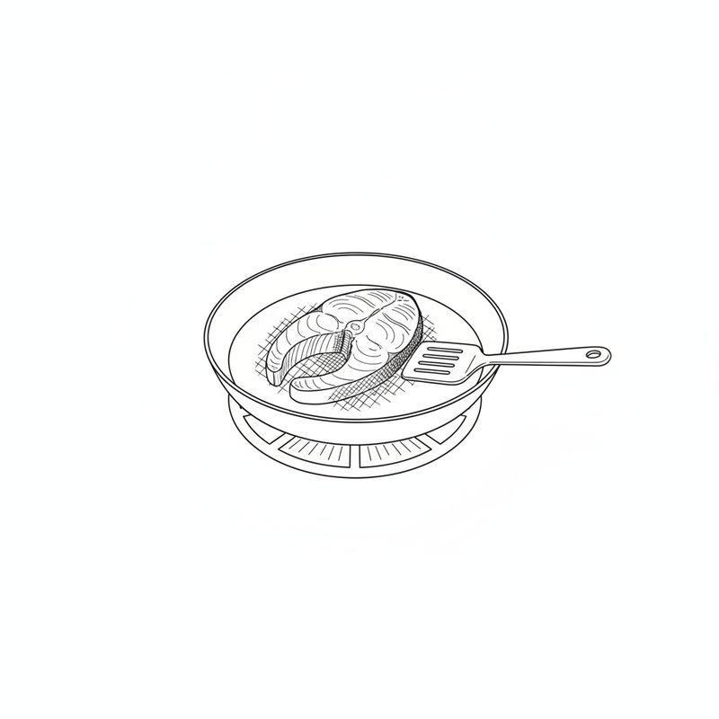 A fish steak frying in a round pan set over a burner, a slotted spatula resting on the pan rim