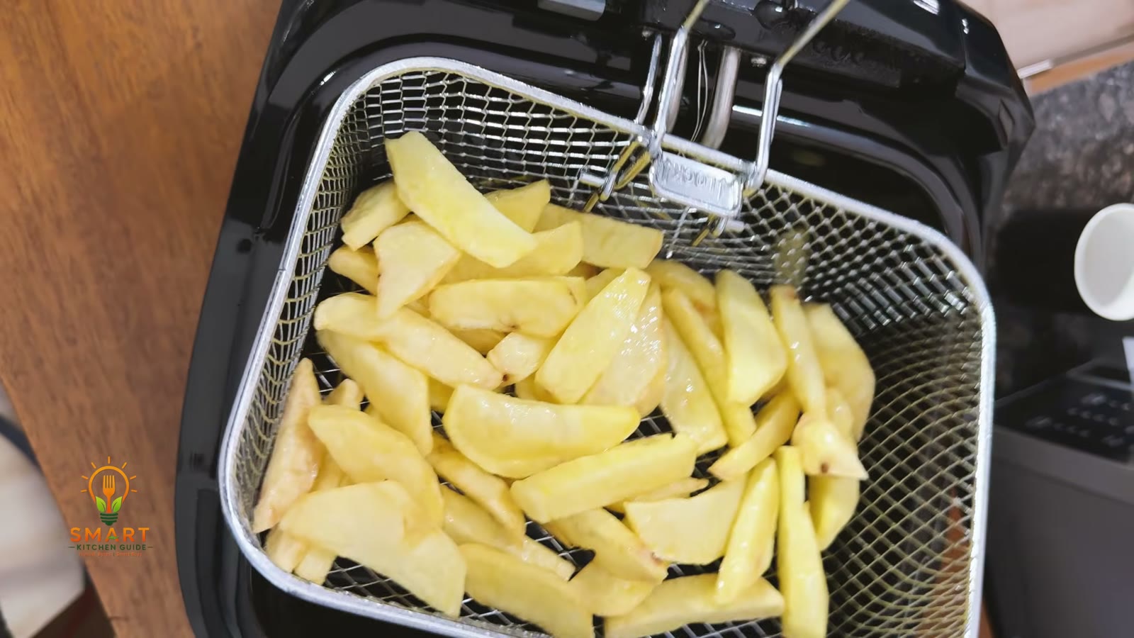 Raw fries filling the wire basket of the Hamilton Beach 35021 deep fryer before frying