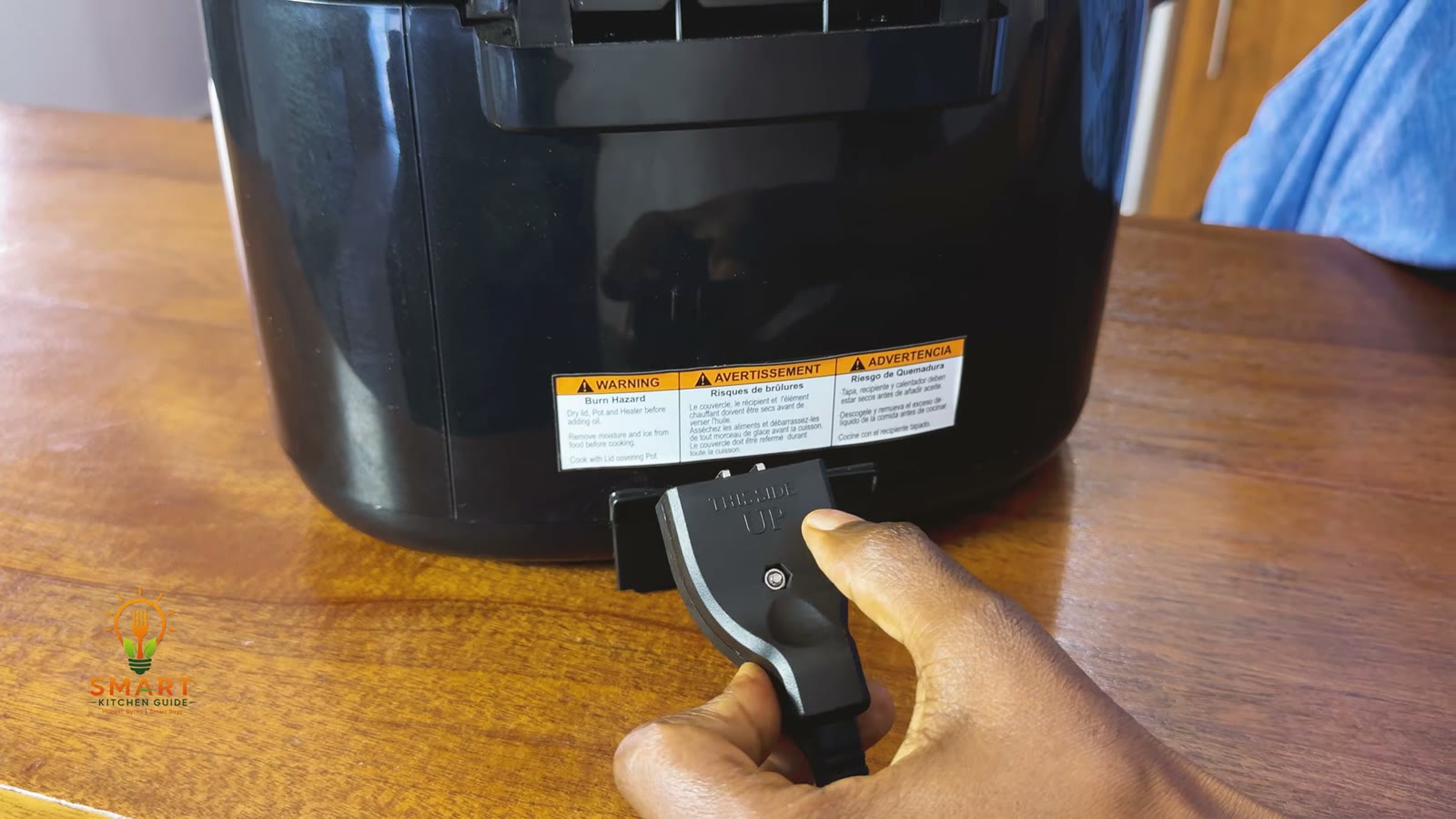 Magnetic breakaway cord plug on the back of the Hamilton Beach 35021 deep fryer with the warning label above it