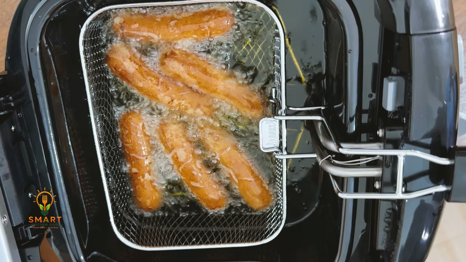 Sausages frying in oil in the wire basket of the Hamilton Beach 35021 deep fryer