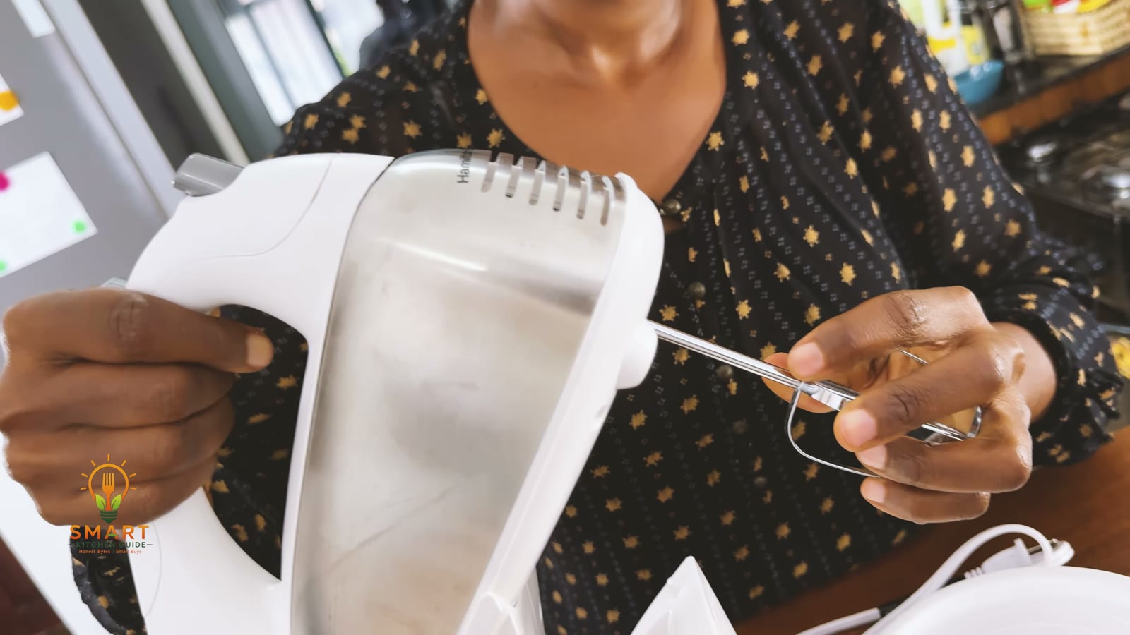 Inserting a beater into the underside of the Hamilton Beach 64655 hand mixer