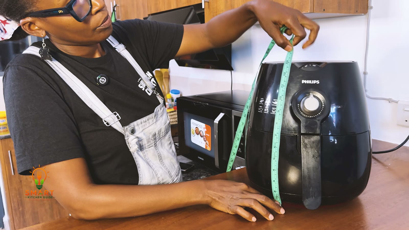 Measuring the height of the Philips Airfryer HD9220 with a tape measure on a kitchen counter