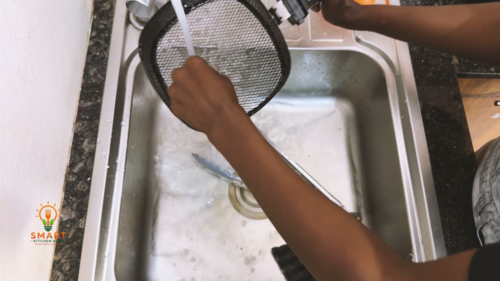 Rinsing the perforated basket of the Philips Airfryer HD9220 under the tap