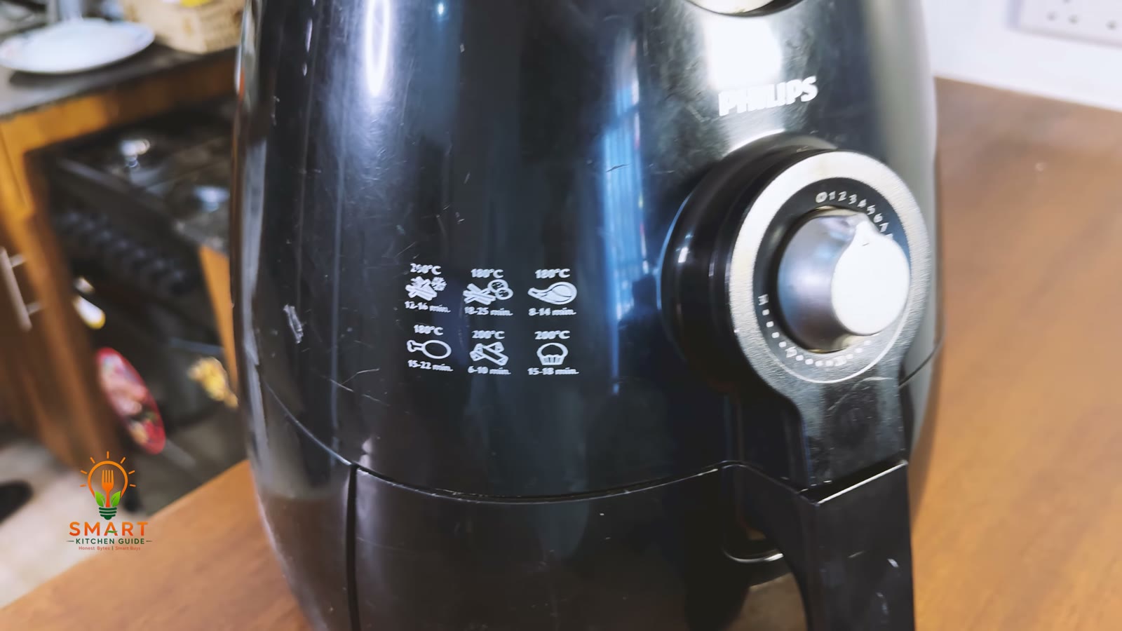 Printed cooking guide on the side of the Philips Airfryer HD9220 showing six foods with temperatures and times
