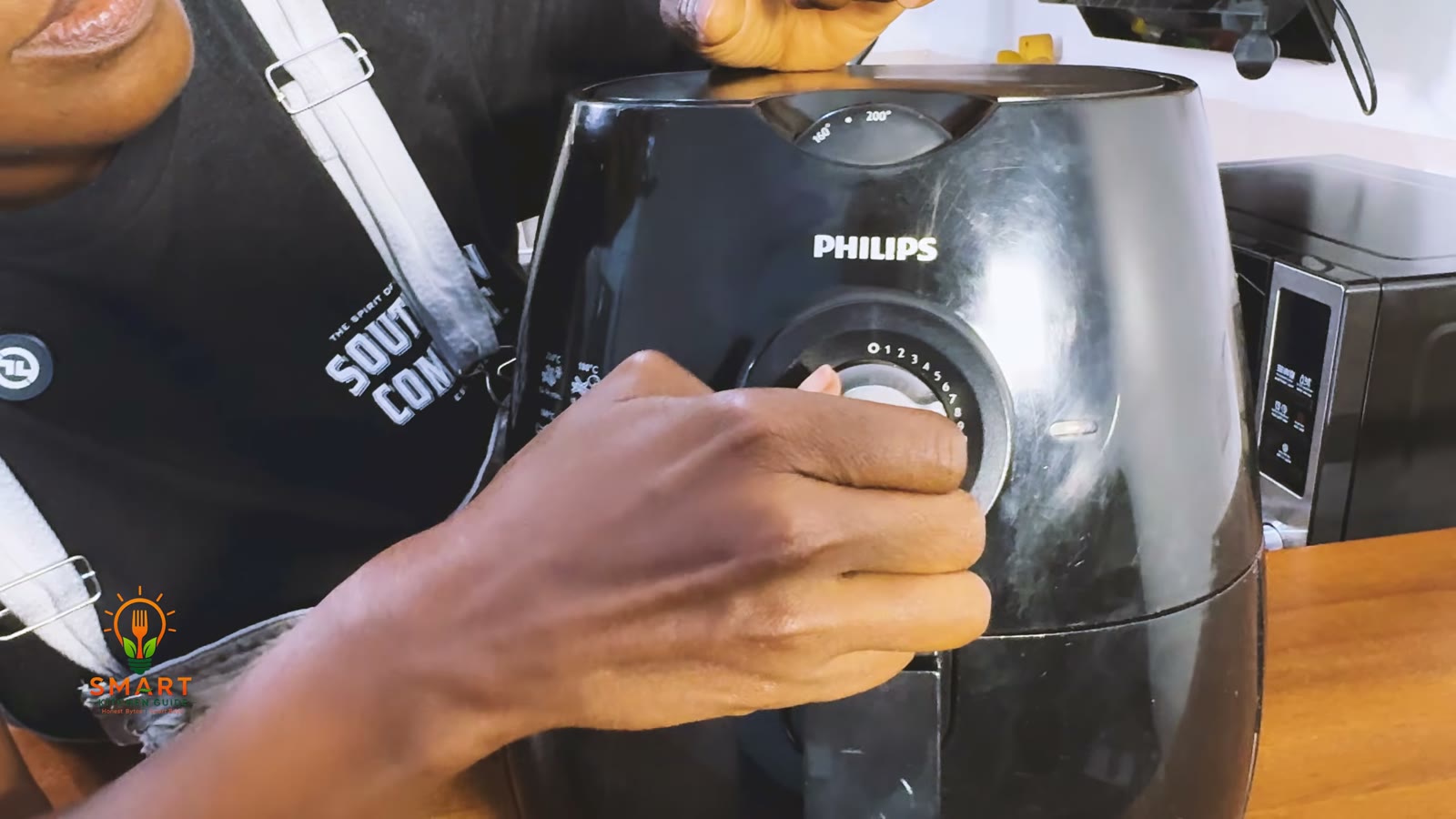 Turning the timer dial on the Philips Airfryer HD9220, with the temperature window printed 160 and 200 on top