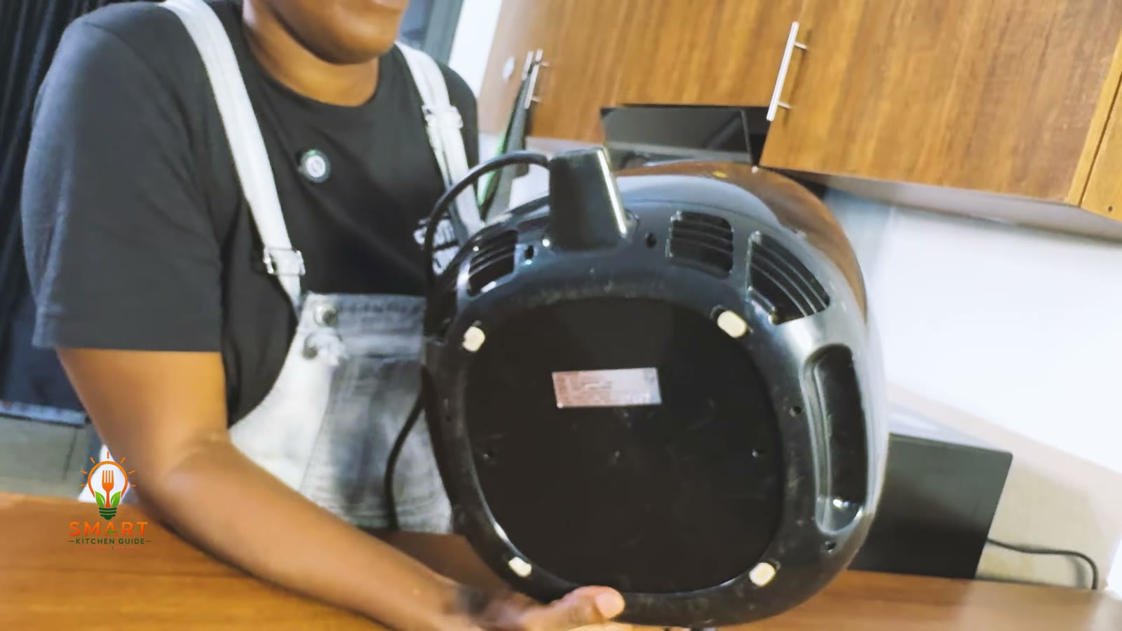 Underside of the Philips Airfryer HD9220 held up to show the rating label, cord and vents